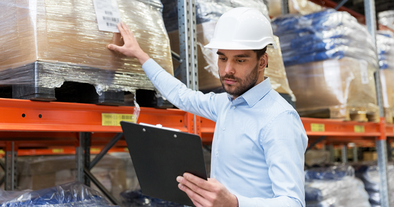 man with hard hat checking inventory_Canva.png