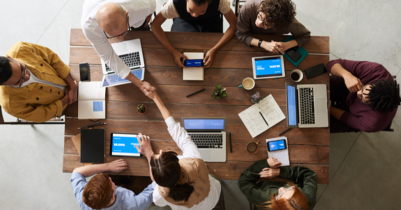 aerial shot of employees meeting around table_Canva.png